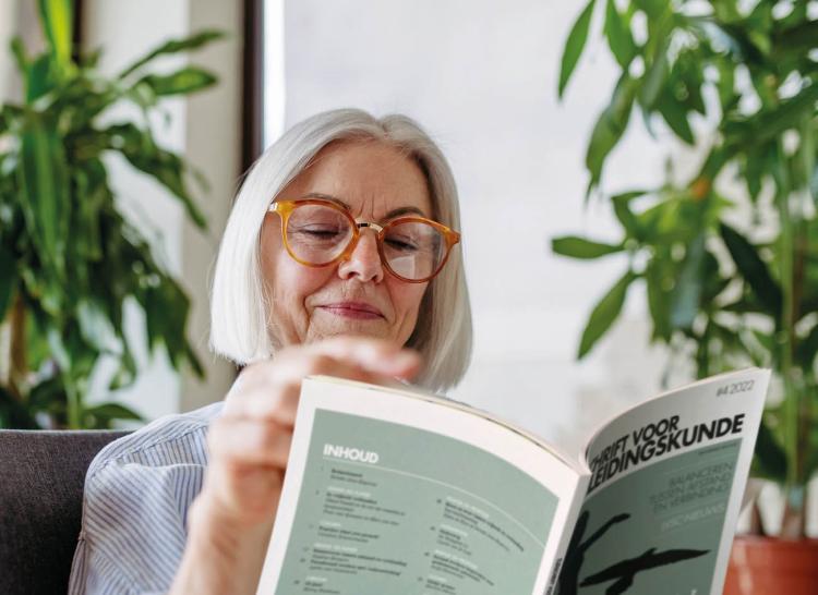 Vrouw die Tijdschrift voor Begeleidingskunde leest